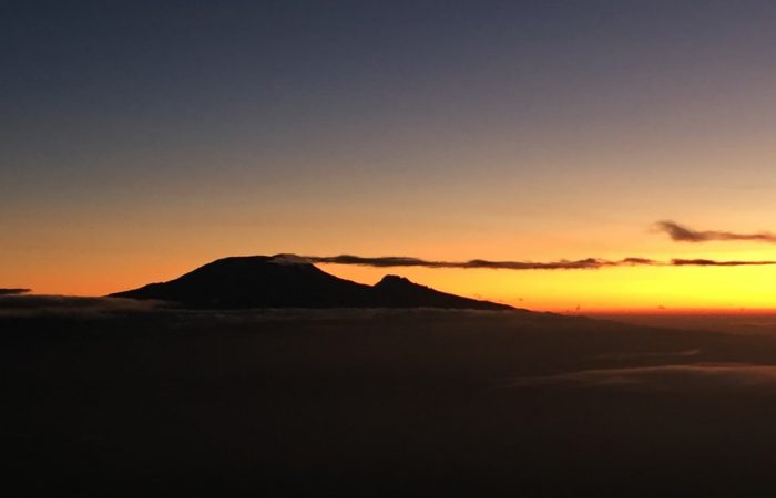Views of surrounding mountain peaks against a sunset as you climb Mt. Meru