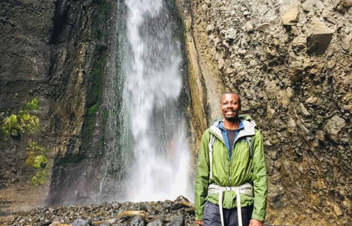 Trekker in front of the Tululusia Waterfall on the 1-day Mt. Meru trek
