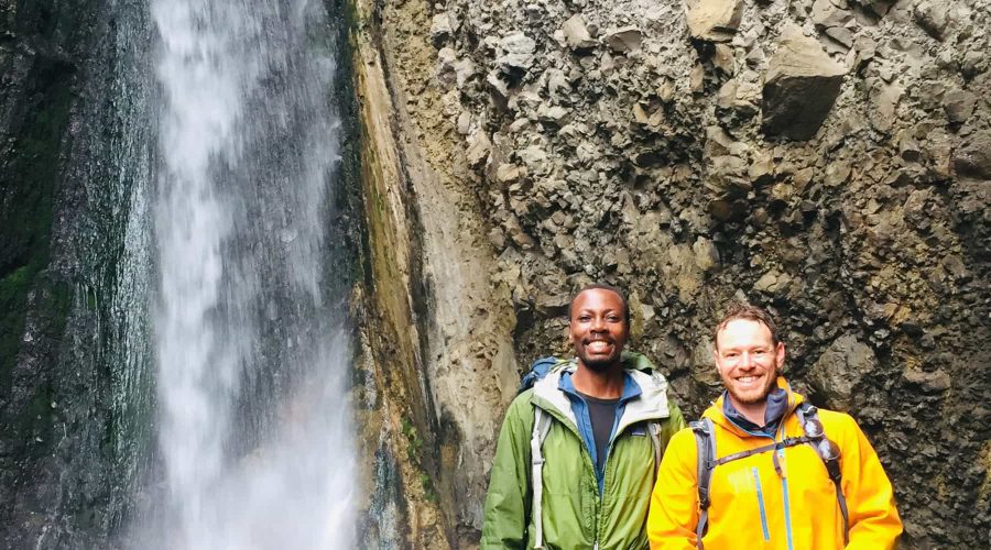 Trekkers in front of the Tululusia Waterfall on the 2-day Mt. Meru trek